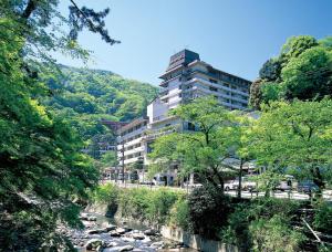 a building in the middle of a river with trees at Hotel Okada in Hakone