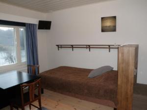 - une chambre avec un lit, un bureau et une table dans l'établissement Ceracon Inn, à Taalintehdas