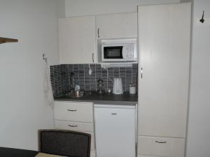 una pequeña cocina con fregadero y microondas en Ceracon Inn, en Taalintehdas