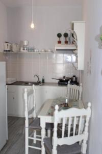 una cocina con mesa y 2 sillas. en Athina's blue studios, en Naousa