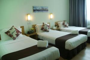 ein Hotelzimmer mit 2 Betten und 2 Tischen in der Unterkunft Tang Dynasty Park Hotel in Kota Kinabalu