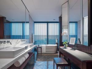 a hotel room with two sinks and a bathtub at NUO Hotel Beijing in Beijing