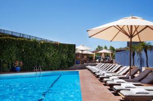a swimming pool with lounge chairs and an umbrella at Four Seasons Hotel Sydney in Sydney
