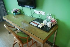 una mesa de madera con 2 sillas y una mesa con bebidas. en Tang Dynasty Park Hotel, en Kota Kinabalu