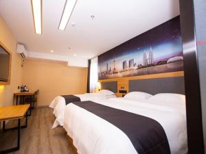 um quarto de hotel com duas camas e uma televisão em Thank Inn Plus Hotel Jiangsu Suzhou Wujiang Tongli Scenic Area Bus Station em Suzhou