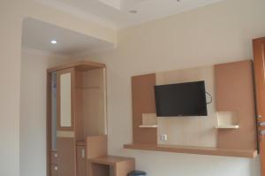 Zimmer mit einem Flachbild-TV an der Wand in der Unterkunft Morse Guest house in Malang