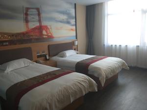 two beds in a hotel room with a painting on the wall at Thank Inn Plus Hotel Hebei Cangzhou Botou Jinji Logistic Park in Cangzhou