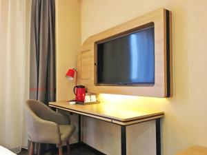 a room with a desk with a tv and a chair at Thank Inn Plus Hotel Henan Anyang Longan District Zhongzhou Road in Anyang