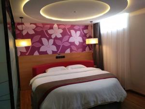 una camera da letto con un grande letto con una parete di fiori rosa di Thank Inn Plus Hotel Shandong Heze Development Zone Huaihe Road a Heze