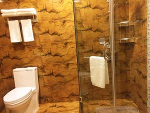 La salle de bains est pourvue de toilettes et d'une douche en verre. dans l'établissement Thank Inn Plus Hotel Jiangsu Huaian Qingpu District Evergrande, à Huai'an
