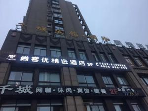 Um edifício alto com escrita chinesa ao lado. em Thank Inn Plus Hotel Anhui Tongling Tongguan District Xihuchuncheng em Yüan-hsien-ch'eng