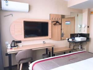 Pokój szpitalny z biurkiem i telewizorem w obiekcie Thank Inn Plus Hotel Shandong Weihai Rongcheng City Chengshan Avenue Rt-mart w mieście Weihai
