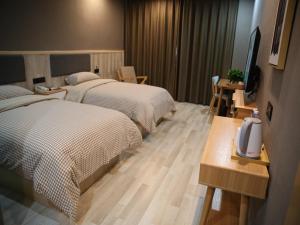 a hotel room with two beds and a flat screen tv at Up And In Hubei Suizhou Zengdu Qinghe Road Shengshihuating in Suizhou