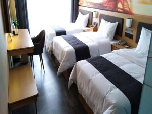 a hotel room with two beds and a table and a desk at Thank Inn Plus Hotel Henan Kaifeng Tongxu county Renmin Road in Kaifeng