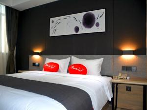 1 dormitorio con 1 cama grande con almohadas rojas en Up And In Fujian Fuzhou Minhou County Shangjie Town Fuzhou University City, en Fuzhou