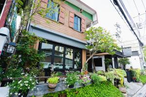 a building with a bunch of plants in front of it at Sabuy Chiangmai in Chiang Mai