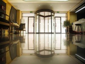 biuro ze szklanymi drzwiami oraz pokój z biurkiem w obiekcie Thank Inn Plus Hotel Shandong Zibo Zhangdian District Jinjing Avenue Wanxianghui w mieście Zibo