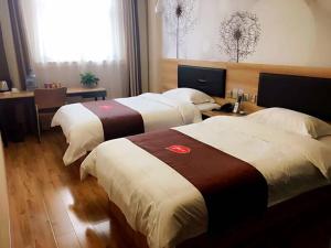a hotel room with two beds and a desk at Thank Inn Plus Hotel Shandong Jining High-tech District Huangtun Plaza Commercial Building in Jining