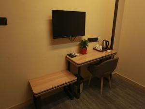a desk with a chair and a television in a room at Thank Inn Plus Hotel Hebei Xingtai Guangzong County North Outer Ring Road in Xingtai