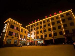 un gran edificio con un estacionamiento delante de él en Thank Inn Plus Hotel Hebei Cangzhou Botou Jinji Logistic Park, en Cangzhou