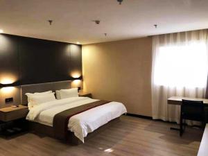 Cette chambre comprend un grand lit et une fenêtre. dans l'établissement Thank Inn Plus Hotel Hebei Shijiazhuang Zhengding New District International Small Commodity City, à Shijiazhuang