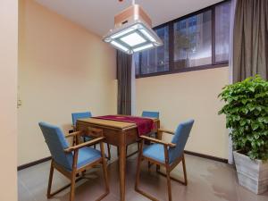 Thank Inn Plus Hotel Sichuan Chengdu Jianyang Dongcheng Huafu في تشنغدو: غرفة طعام مع طاولة وكراسي زرقاء