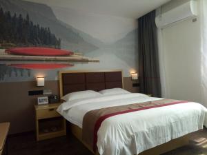 una camera da letto con un grande letto e un dipinto sul muro di Thank Inn Plus Hotel Jiangxi Fuzhou Jinxi County Government Square a Fuzhou