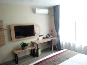 Habitación de hotel con cama, escritorio y TV. en Thank Inn Plus Hotel Anhui Xuancheng Xuanzhou District Shengshiyujing en Xuancheng