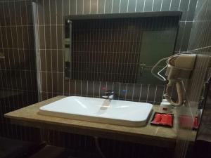 een wastafel in de badkamer met een spiegel en een telefoon bij Thank Inn Plus Hotel Jiangxi Fuzhou Jinxi County Government Square in Fuzhou