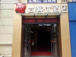 une entrée à un bâtiment avec un panneau sur celui-ci dans l'établissement Thank Inn Plus Hotel Anhui Xuancheng Xuanzhou District Shengshiyujing, à Xuancheng