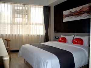 una habitación de hotel con una cama grande con almohadas rojas en Up And In Fujian Fuzhou Minhou County Shangjie Town Fuzhou University City, en Fuzhou