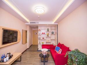 salon z czerwoną kanapą i telewizorem w obiekcie Thank Inn Plus Hotel Hubei Jingzhou City Jingzhou District Railway Station w mieście Jingzhou
