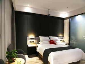 TaizhouにあるThank Inn Plus Jiangsu Taizhou Renmin Hospitalのベッドルーム1室(大型ベッド1台、赤いぬいぐるみ付)