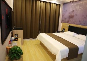 1 dormitorio con 1 cama grande y TV en Thank Inn Plus Hotel Shandong Qingdao Jimo Development Zone New Government en Qingdao