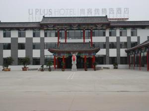 een groot gebouw met een standbeeld ervoor bij Thank Inn Plus Hotel Shandong Qufu Kongfu in Jining