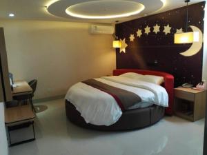 una camera da letto con un letto con luna e stelle sul muro di Thank Inn Plus Hotel Shandong Heze Development Zone Huaihe Road a Heze
