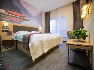 a hotel room with a large bed and a table at Thank Inn Plus Hotel Hebei Handan Congtai District Lianfang West Road in Handan