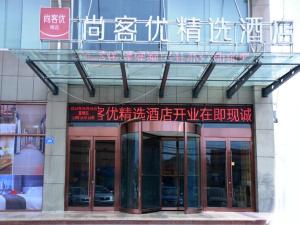 un bâtiment avec des écrits chinois sur son côté dans l'établissement Thank Inn Plus Hotel Shandong Jinan Jiyang HuaYang Road, à Jiyang