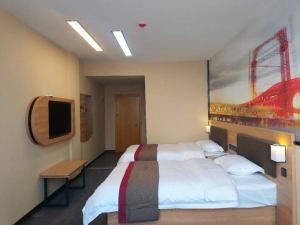 um quarto de hotel com uma cama grande e uma televisão em Thank Inn Plus Hotel Shandong Rizhao Ju County Chengyang South RoadHospital of Chinese Traditional Medicine em Rizhao