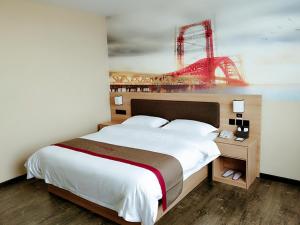 a bedroom with a large bed with a red bridge on the wall at Thank Inn Plus Hotel Shandong Binzhou Huimin County Huji Driving Test Center in Binzhou