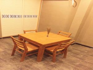 - une table en bois avec 2 chaises et un vase dans l'établissement Thank Inn Plus Hotel Jiangsu Huaian Qingpu District Evergrande, à Huai'an