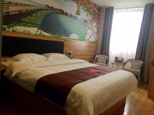 a bedroom with a large bed with a painting on the wall at Thank Inn Plus Hotel Shandong Jining High-tech District Huangtun Plaza Commercial Building in Jining