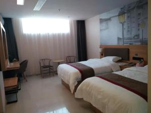 a hotel room with two beds and a table at Thank Inn Plus Hotel Shandong Heze Development Zone Huaihe Road in Heze