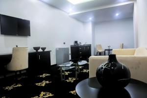 a living room with a couch and a vase on a table at BON Hotel Ikeja Residence in Ikeja