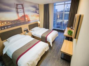 a hotel room with two beds and a large window at Thank Inn Plus Hotel Hebei Handan Congtai District Lianfang West Road in Handan