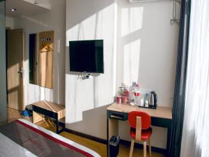 a room with a desk with a red chair and a television at Thank Inn Plus Hotel Gansu Pingliang Kongtong District Fengshou Road in Pingliang