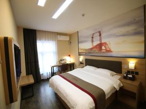 a hotel room with a large bed and a painting at Thank Inn Plus Hotel Shandong Jining Qufu City Sankong Tourist Center in Jining