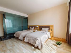 two beds in a large room with at Up And In Anhui Wuhu Anhui University of Engineering in Wuhu