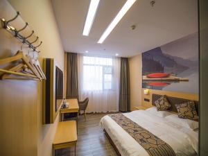 Pokój hotelowy z łóżkiem i biurkiem w obiekcie Thank Inn Plus Hotel Hubei Jingzhou City Jingzhou District Railway Station w mieście Jingzhou