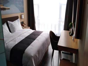 a bedroom with a bed and a desk and a window at Thank Inn Plus Hotel Henan Kaifeng Tongxu county Renmin Road in Kaifeng